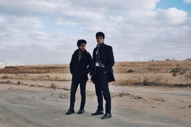 two men standing in front of a road