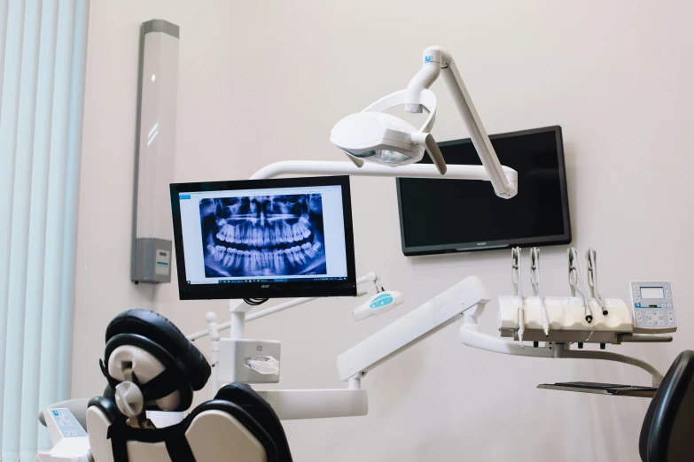 a computer monitor on the wall in a dentist room