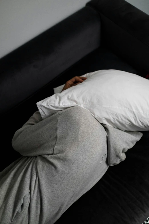 a woman laying in bed with an oversized pillow