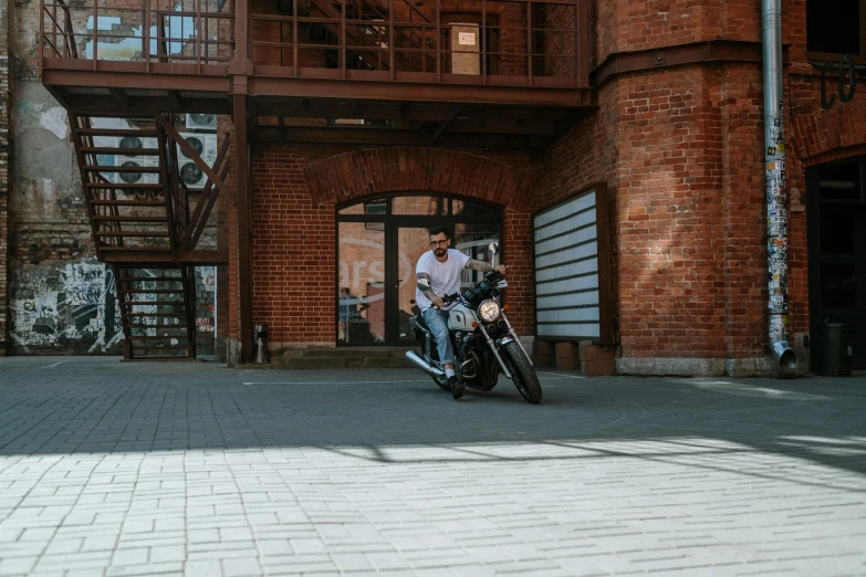 a man riding a motorcycle down a sidewalk