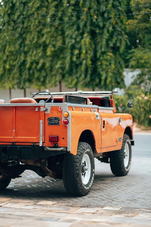 the orange pick up truck is parked on the street