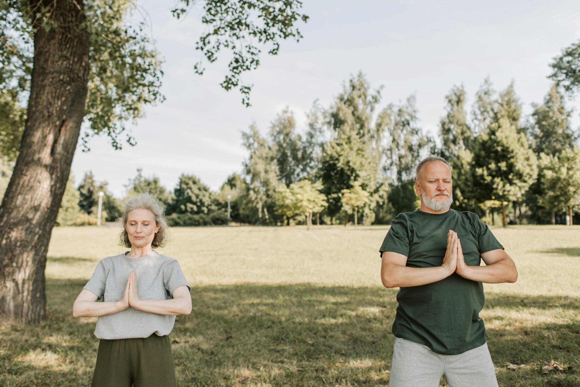 the man and woman are doing yoga outside