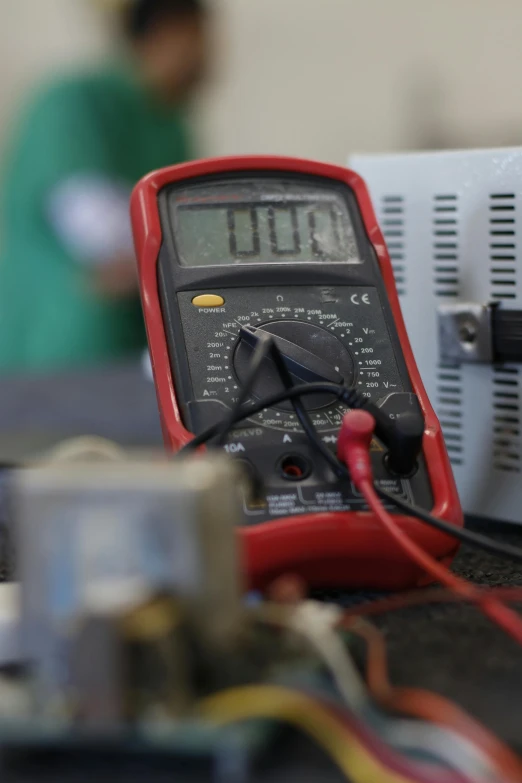a multimeter sits on a table next to a device