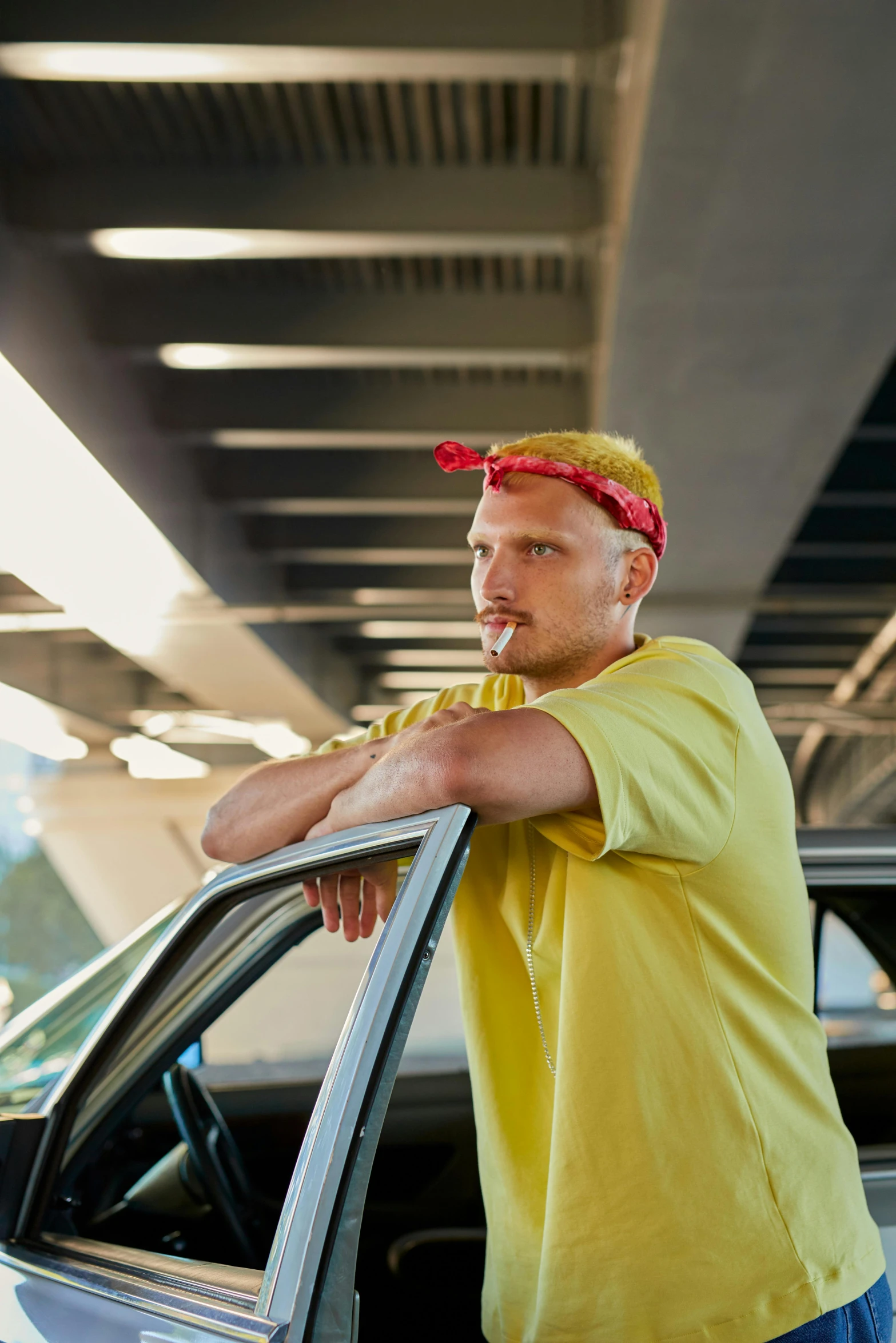 a man with yellow hair sticking his tongue out from the top of his car