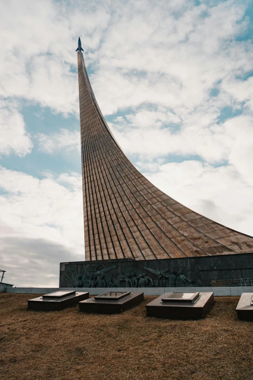 there are three stone sculptures in front of a very tall building