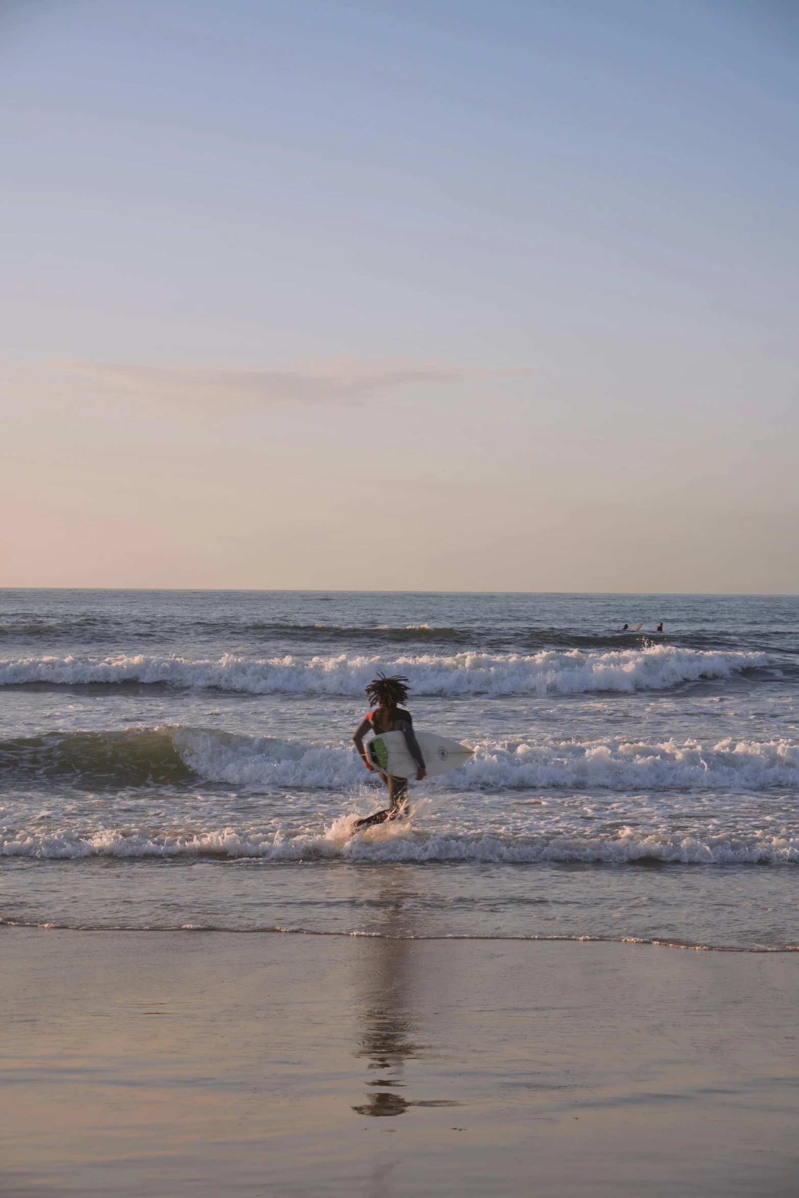 a surfer standing on a beach as it surfs