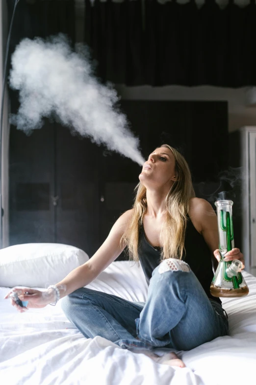 a woman sitting on her stomach holding a green cigarette