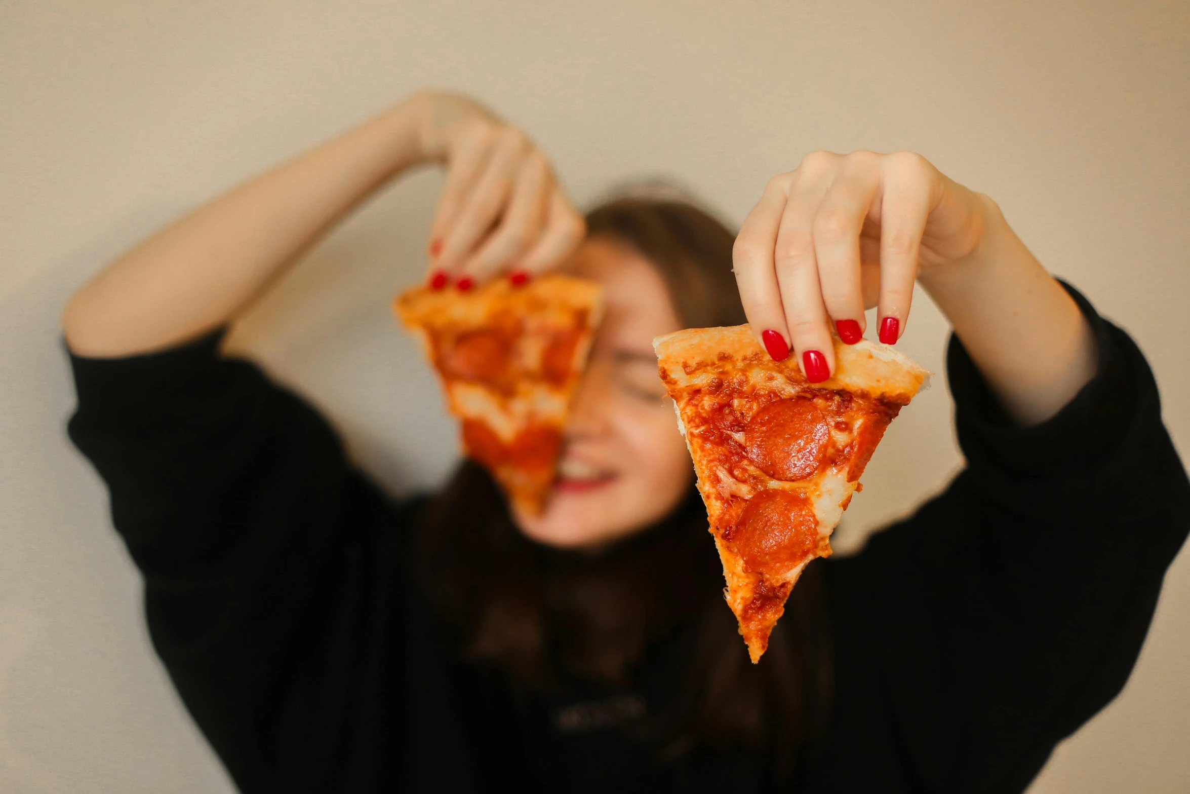 woman taking a bite out of a slice of pizza