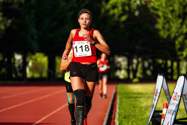 female runner competing in outdoor race course on grassy field