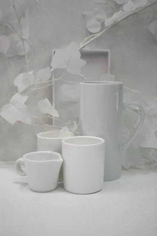 three white cups in front of a gray background