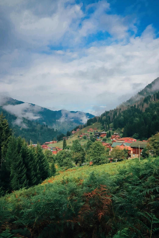 there are houses on the hillside with clouds