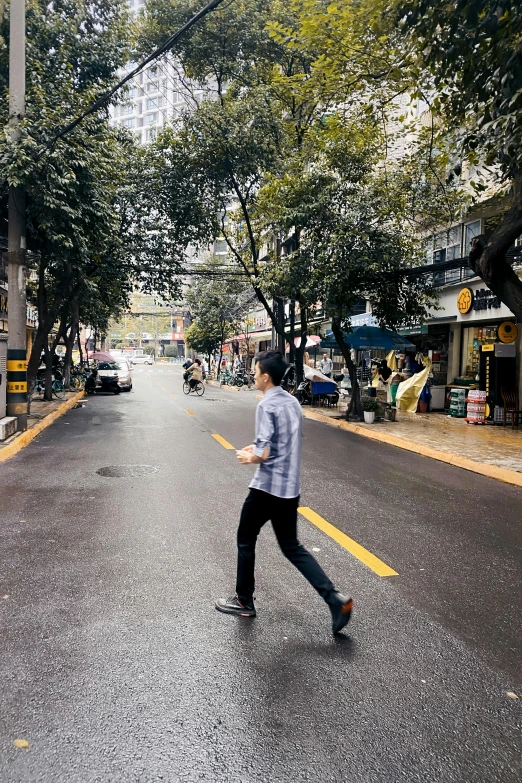 man walking on street in the middle of trees