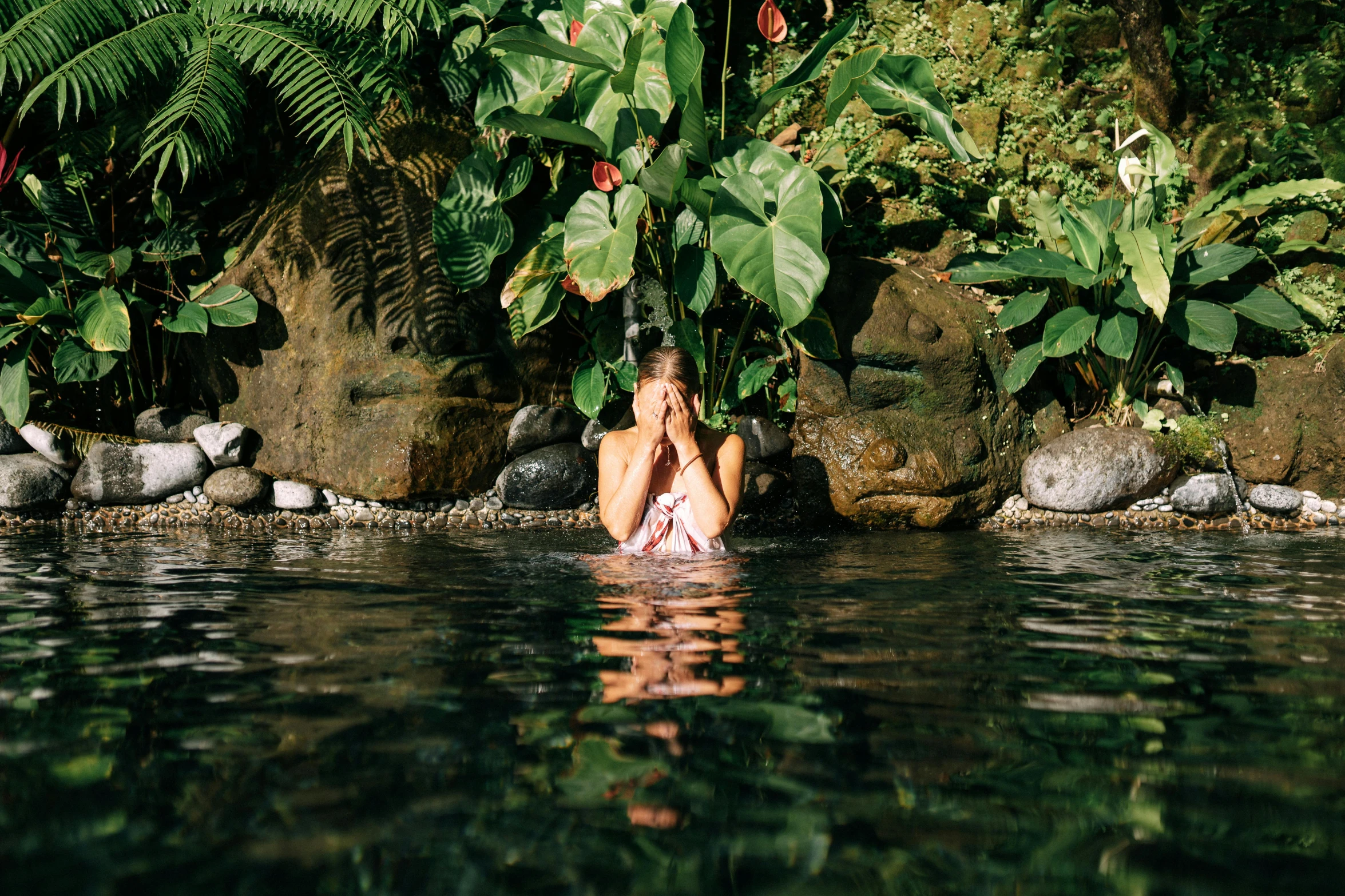 a man sitting in the middle of some water with his feet up to the surface