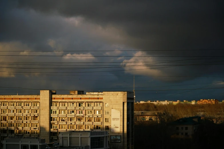 a view from a rooftop of buildings with storm clouds looming over them