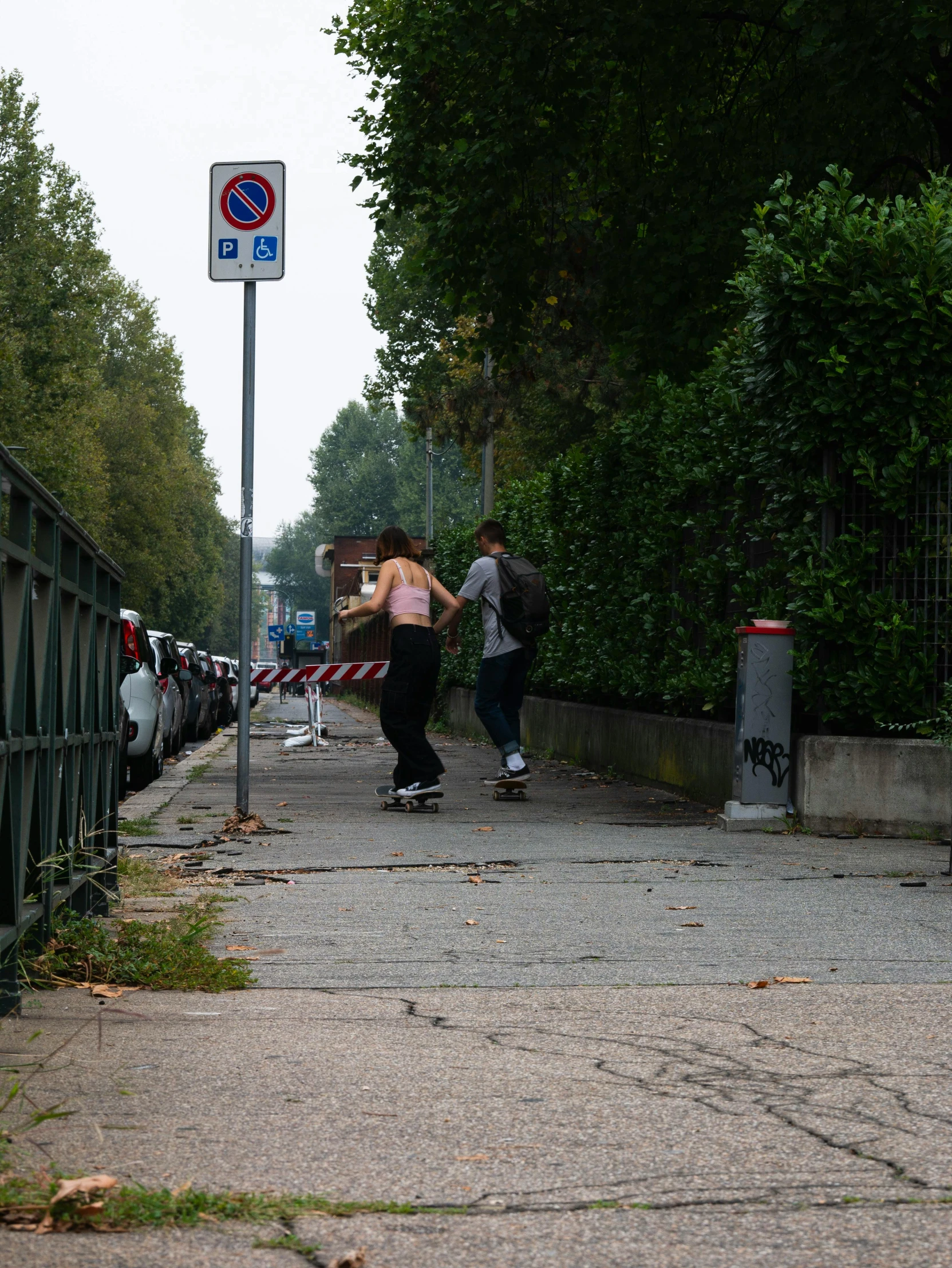 a group of skateboarders walking along the side of the road