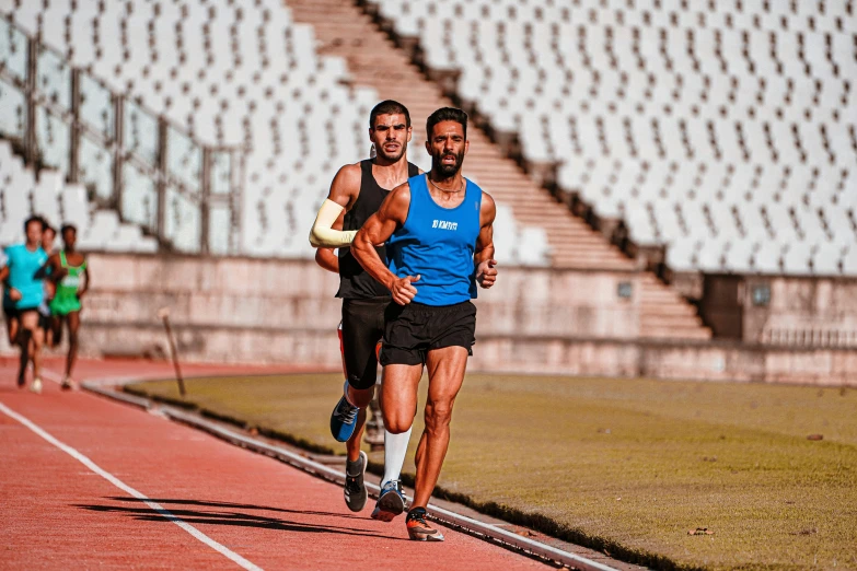 three men running in a track on a red track