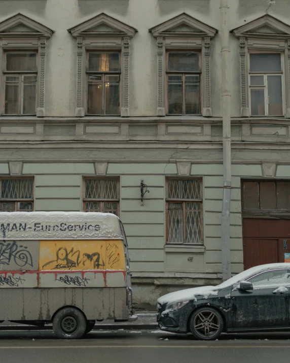 a city street with a van and a car in front