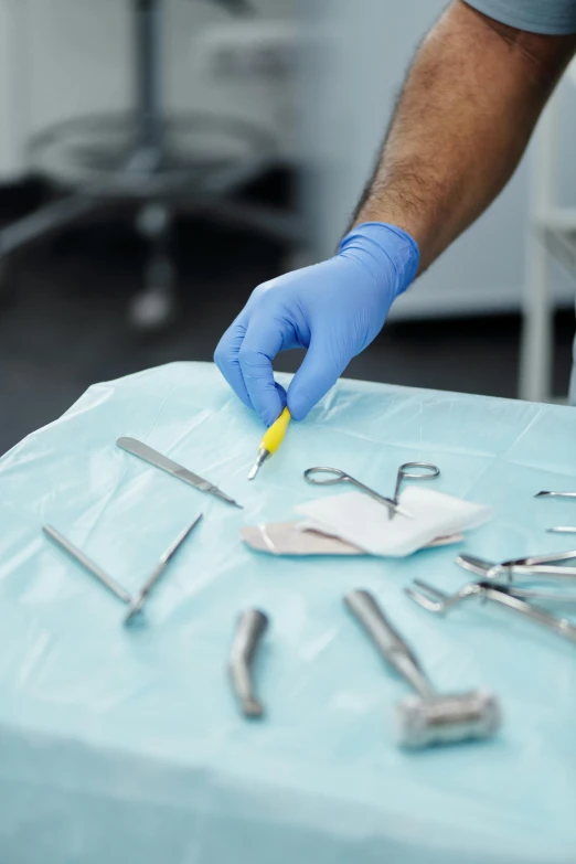 a person with a glove on is making dental tools