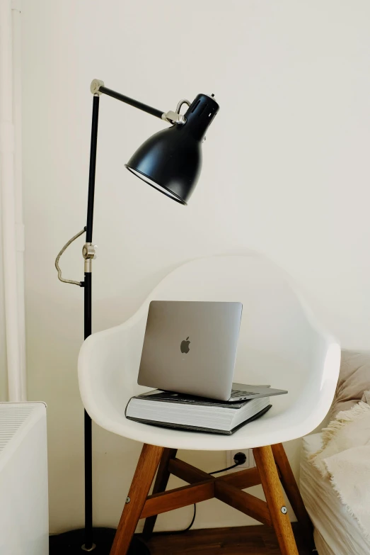 a laptop sitting on top of a white chair