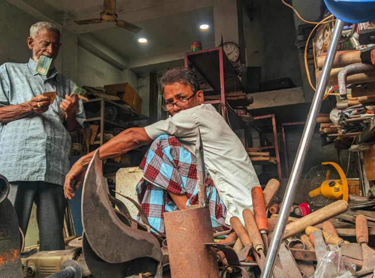 a man standing behind a wooden spinning wheel in a shop