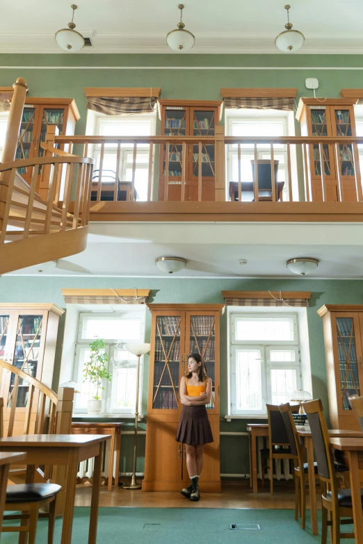 the young woman is standing in front of the stairs