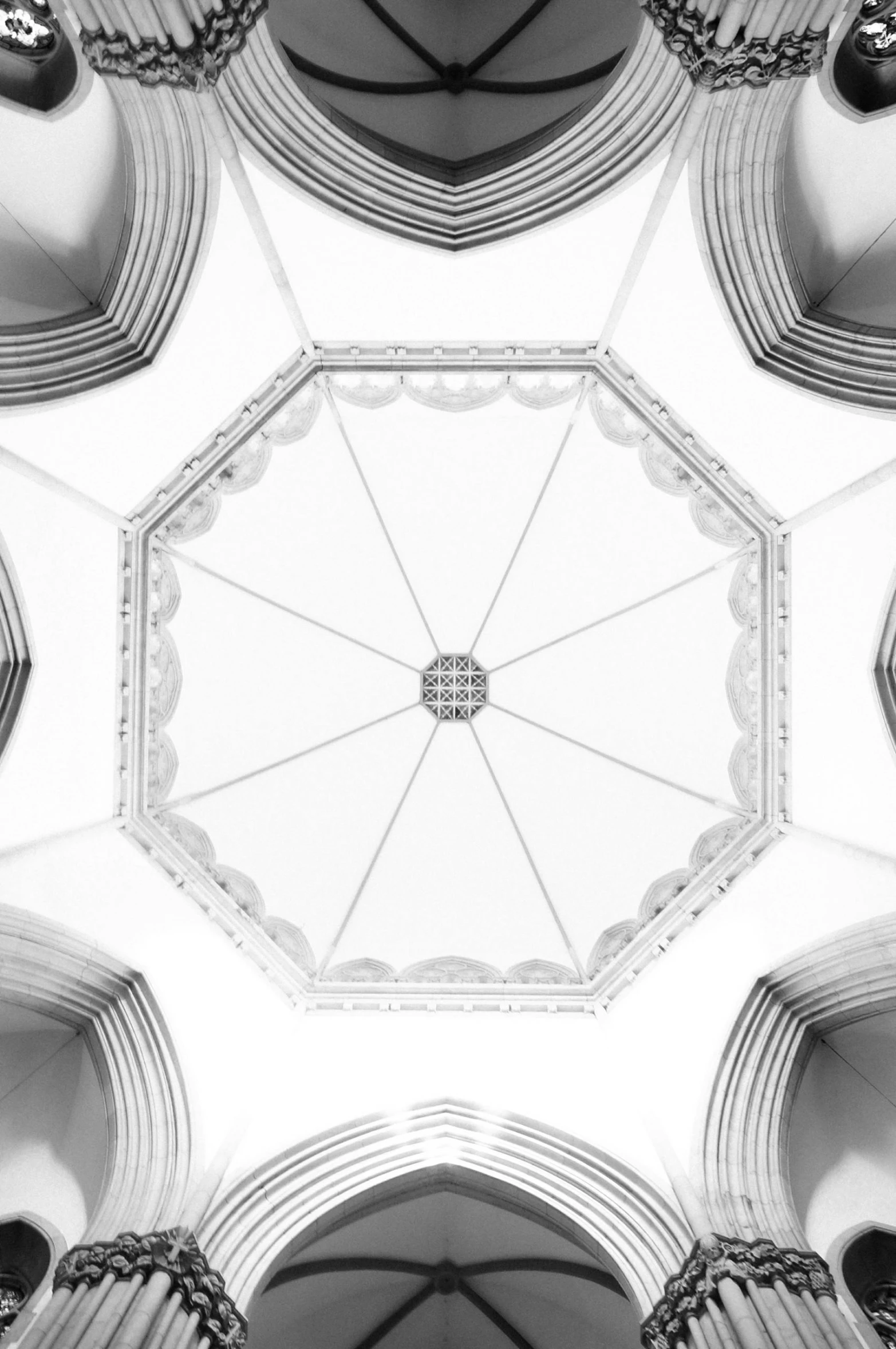 the underside view of a white dome with ornate arches