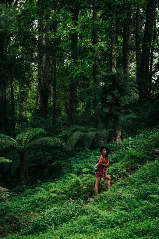 a young child wearing a red top running in the woods