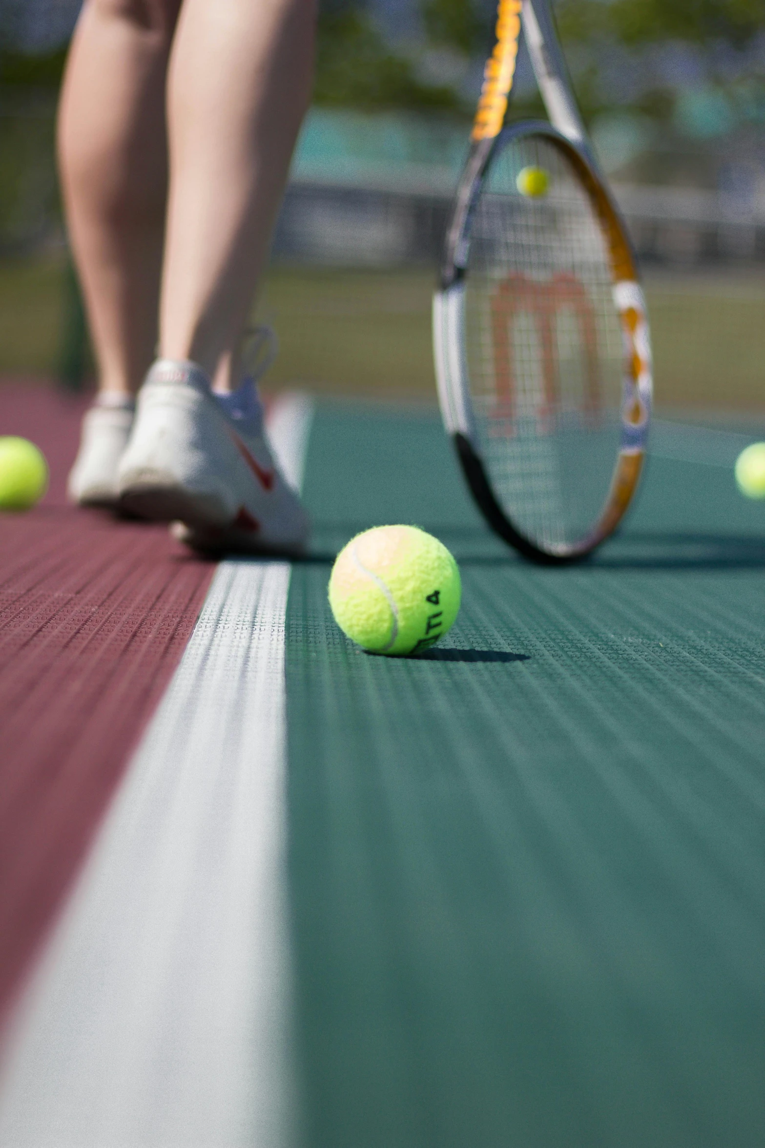 a tennis ball sitting in front of the racket and a person