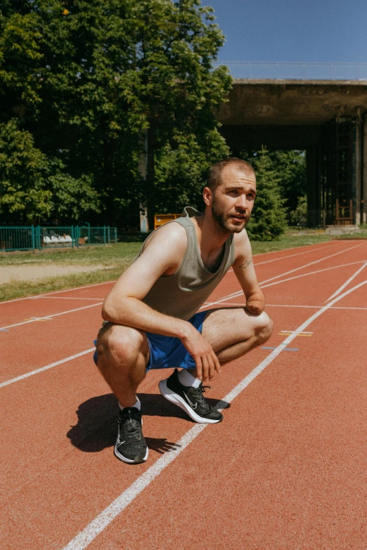 man squatting on the ground with his feet crossed