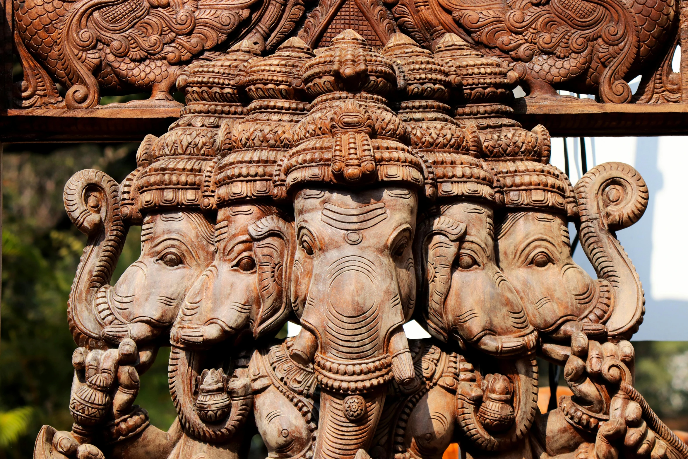 some carved wood of elephants on display