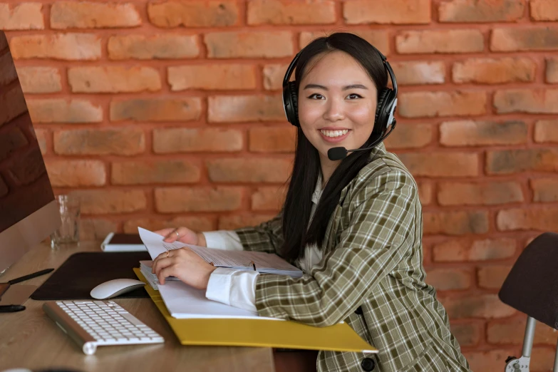 woman with headset sitting at computer desk while using keyboard