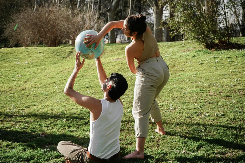 a man kneeling down and a woman holding a basketball ball
