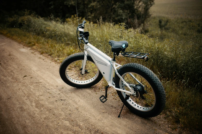 there is a bike on the side of a dirt road