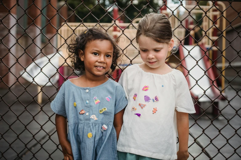 a couple of s standing by a fence