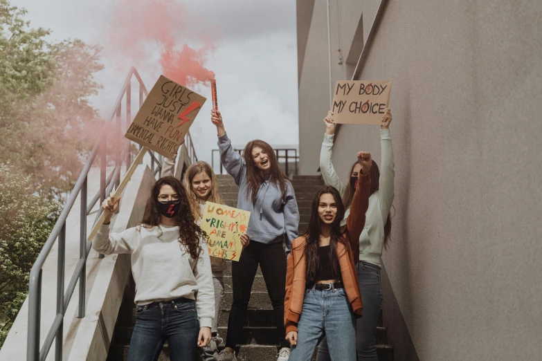 people in protest signs on steps outside