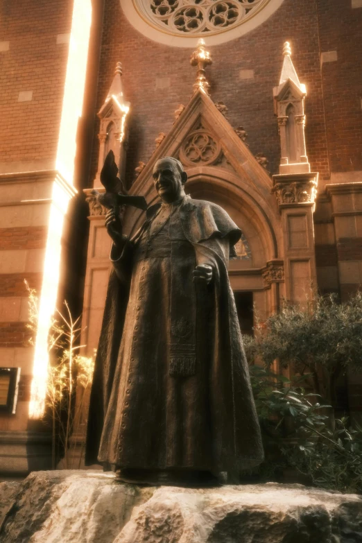 a statue with a sword and in a hat is standing next to an ornate church