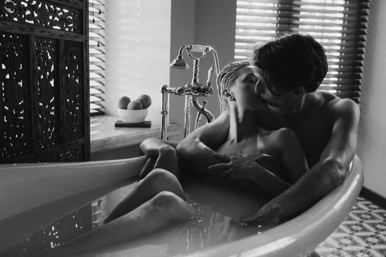 black and white pograph of a couple emcing in an oval bathtub