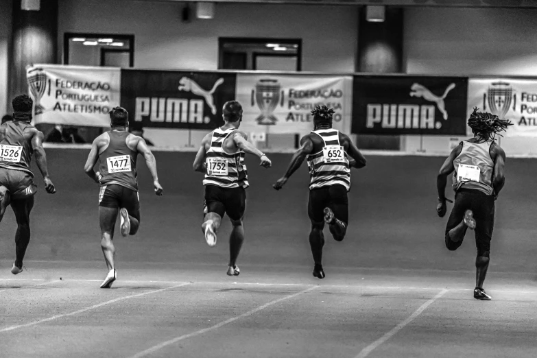 an indoor race course with three men competing in the same race