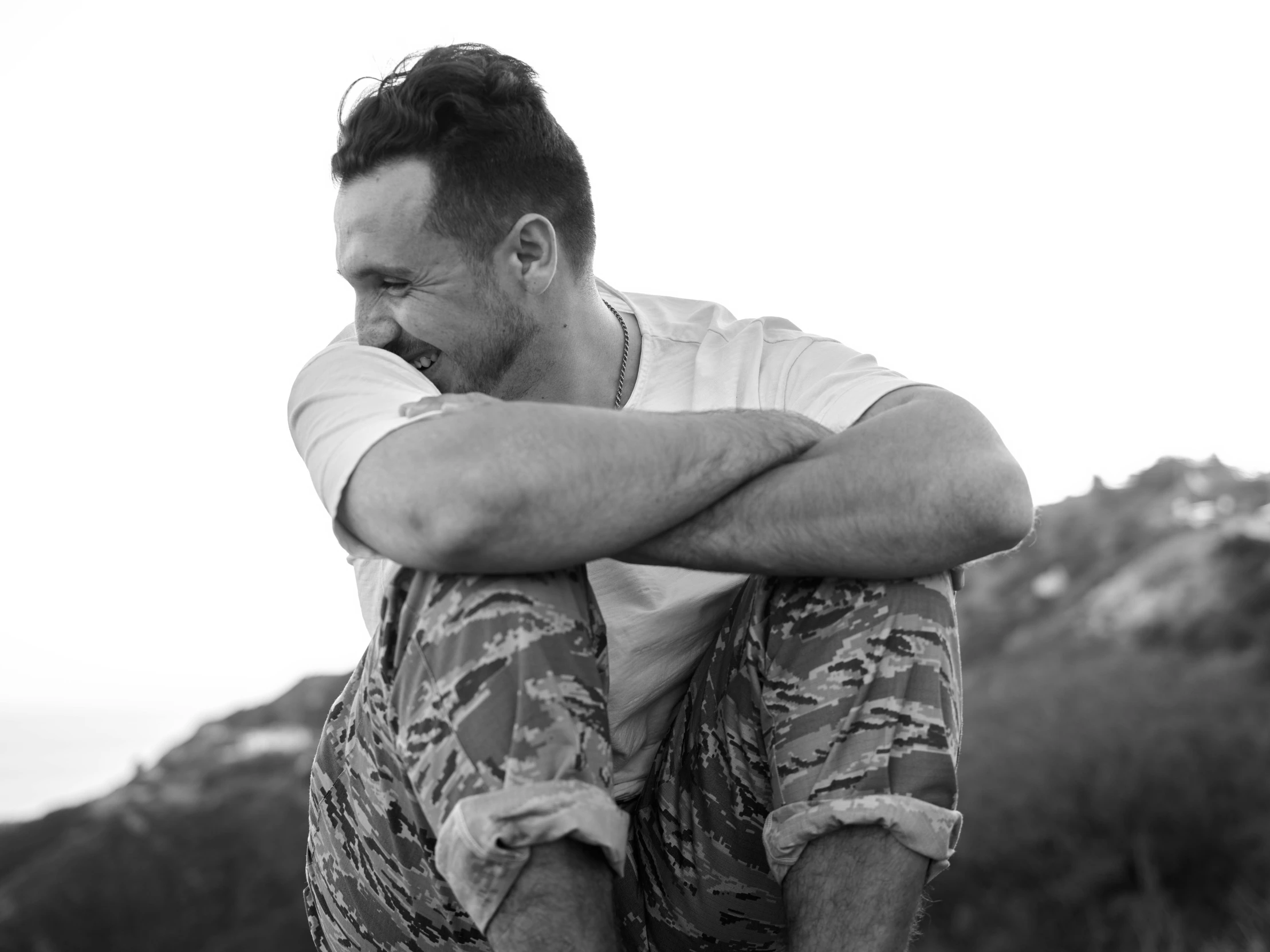 man sitting on top of a rock in the mountains