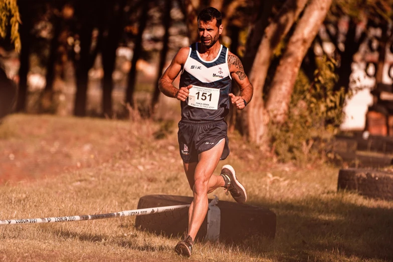 a man wearing blue running past a bunch of trees