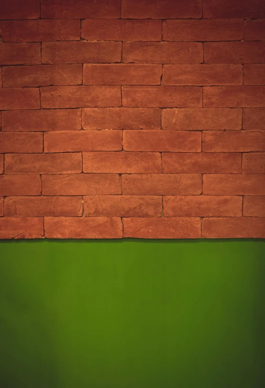 an orange brick wall over green grass