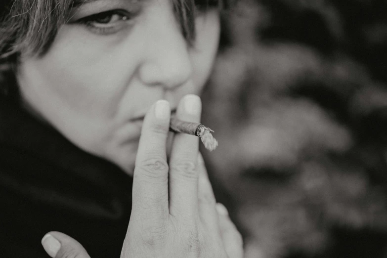 a young woman is smoking while posing for the camera