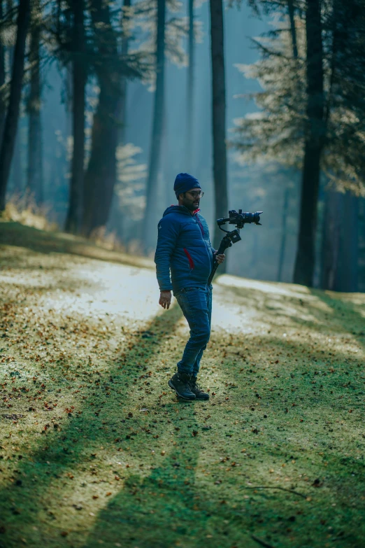 a man walking in the woods carrying an object