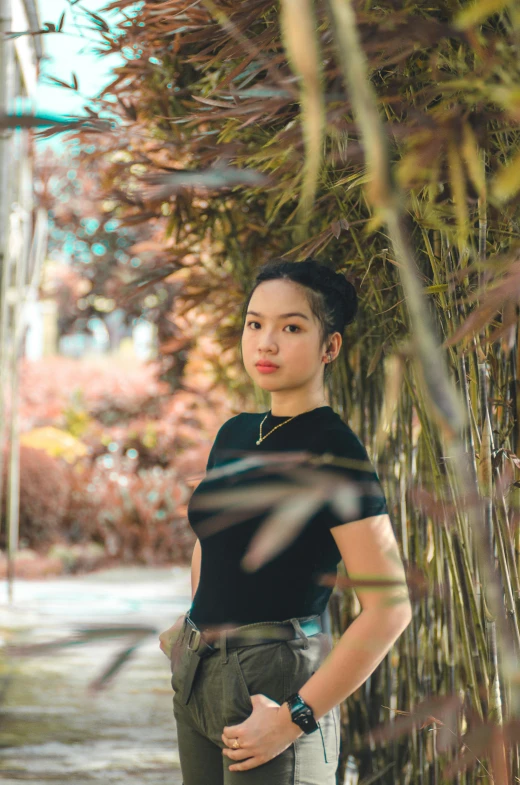 a woman posing next to a wall covered in grass