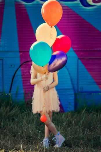 a girl standing with several balloons up in the air