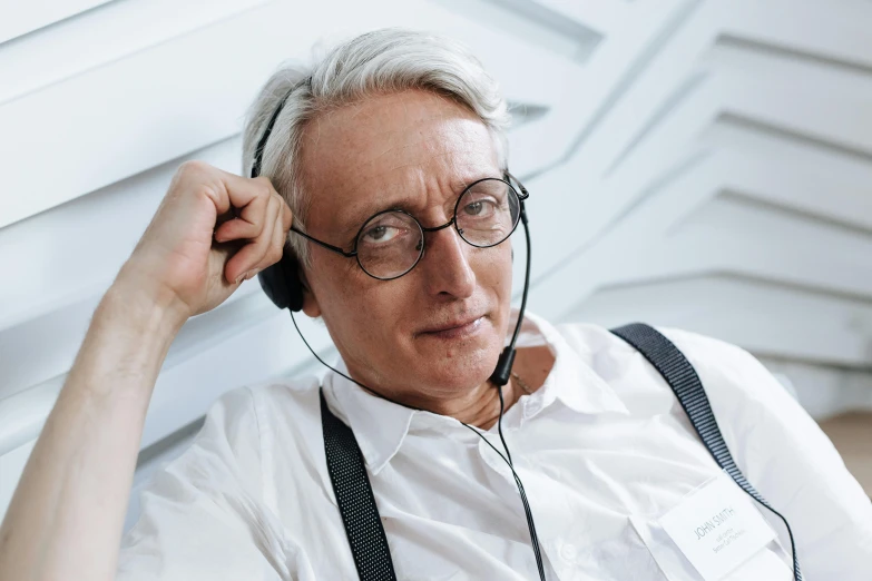 an elderly man wearing headphones looking into the distance