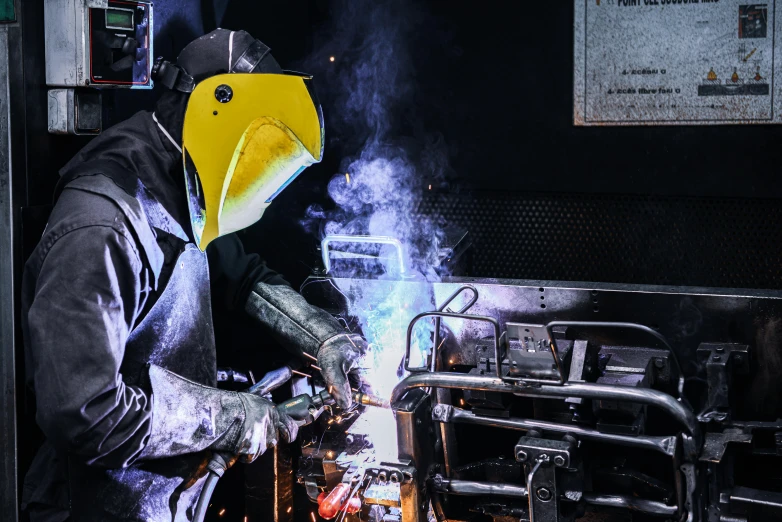 the man in a yellow helmet is working on a machine