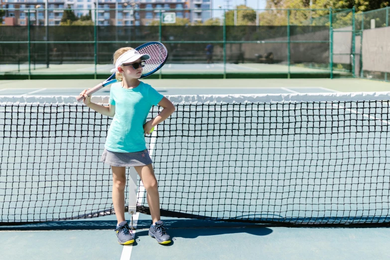 there is a young child playing tennis on a court