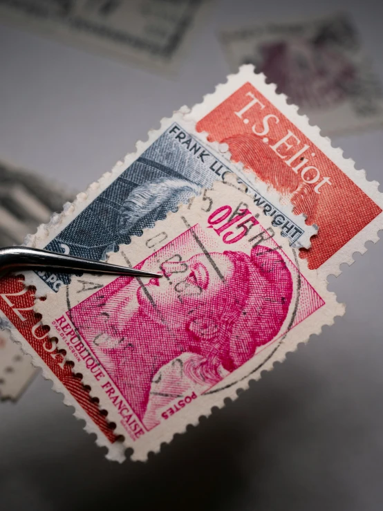 scissors  through the end of a red and black stamps