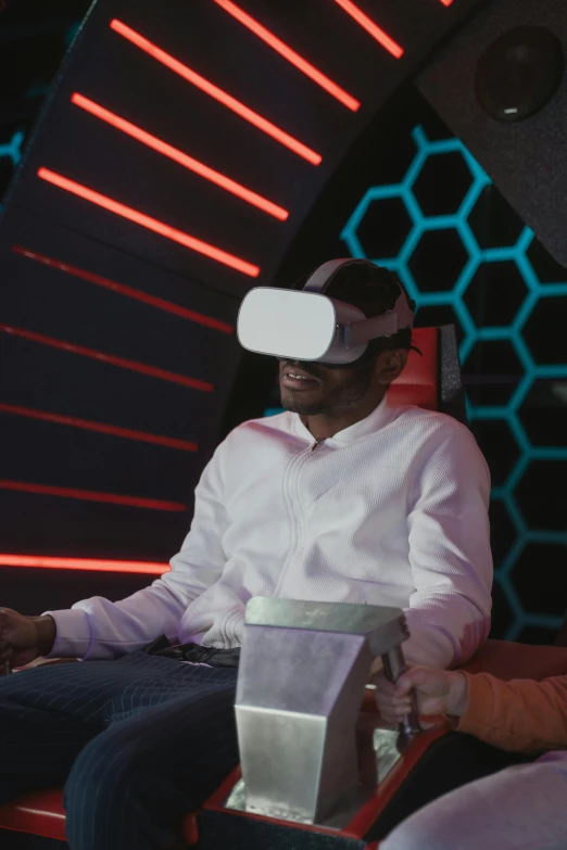 two people are sitting in chairs with virtual reality headsets